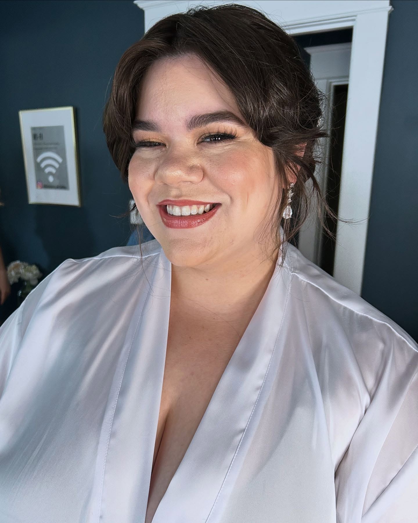 Smiling bride with finished makeup and softly styled dark hair