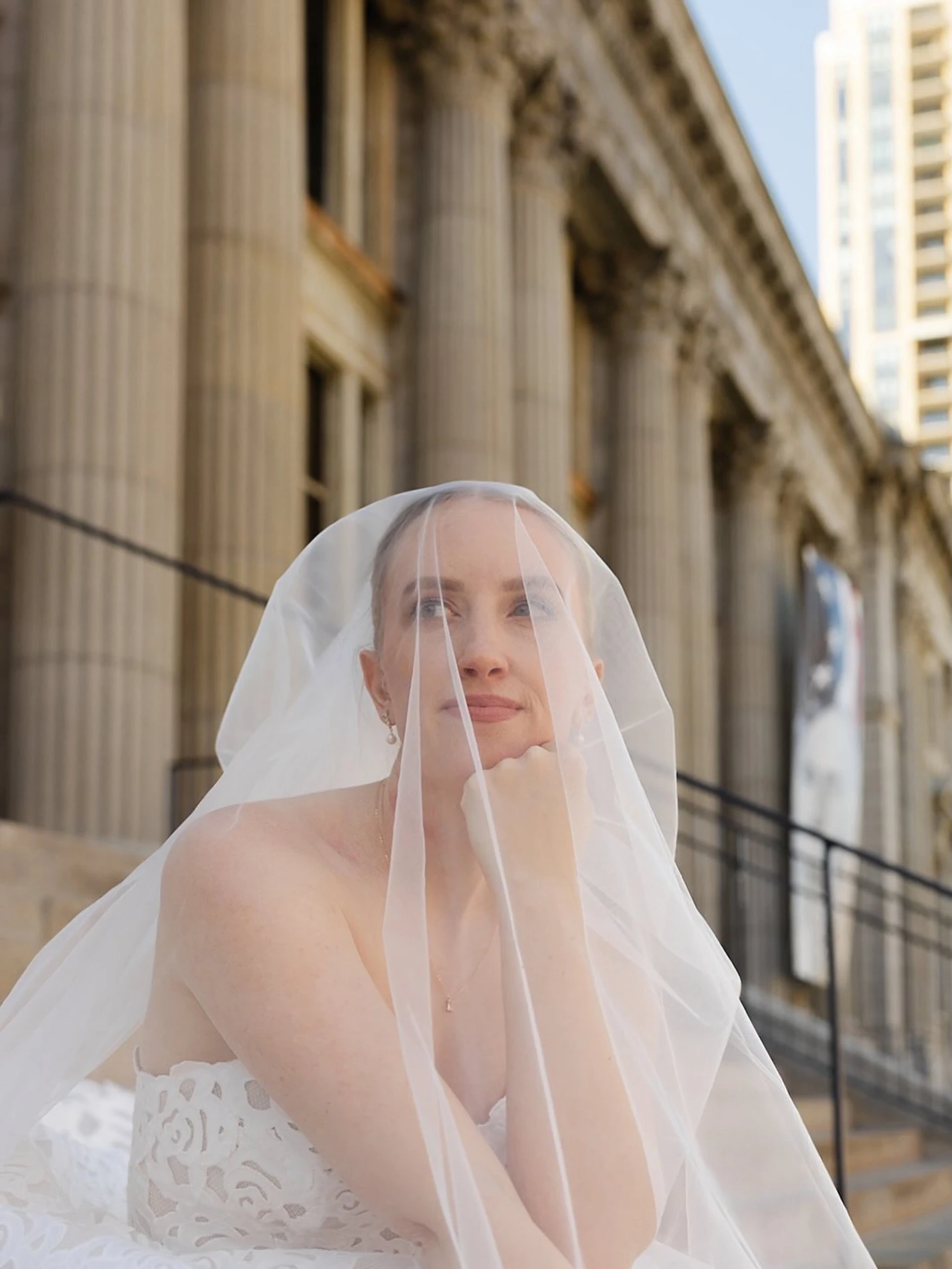 Bride under veil outside a historic stone building